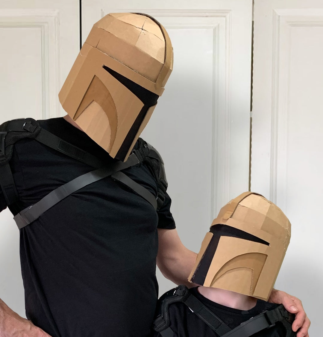A father a son wearing a Mandalorian inspired cardboard helmet. 