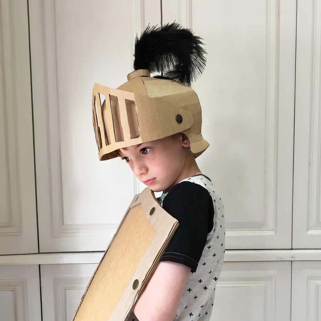 DIY cardboard knights helmet and shield on a white background