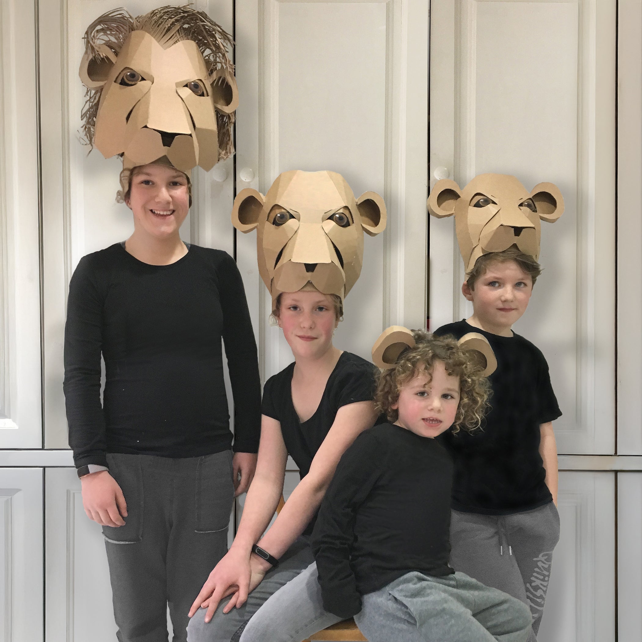 Cardboard lion headdresses inspired by the lion king, with a lion, lioness and cubs.